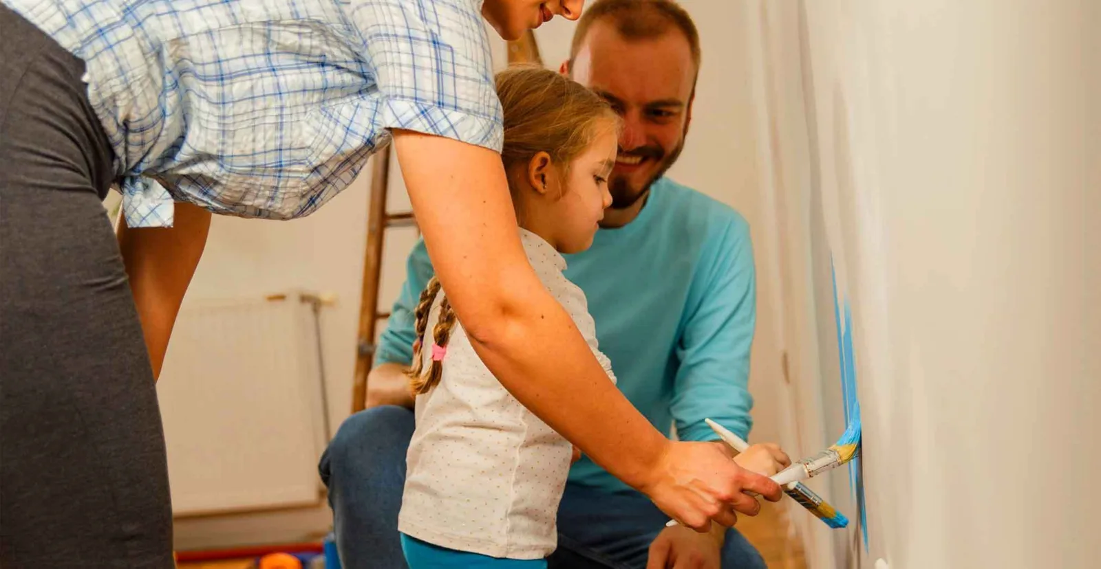 Young girl helping decorate wall