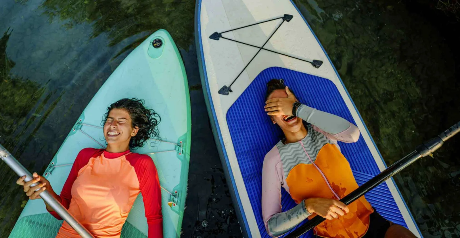Friends enjoying paddle boarding on holiday